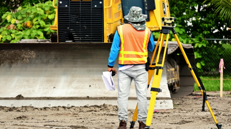 A professional land surveyor and licensed civil engineer collaborating on site layouts and boundary lines.