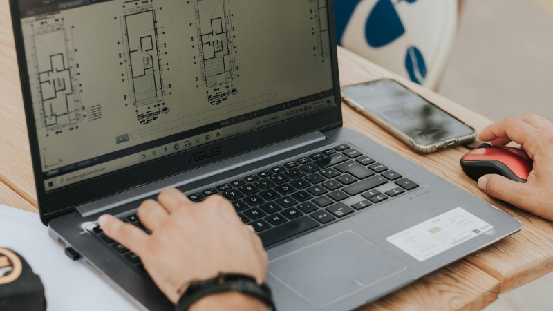 A digital designer utilizing GIS mapping and CAD software to draft a permit-ready site plan online.