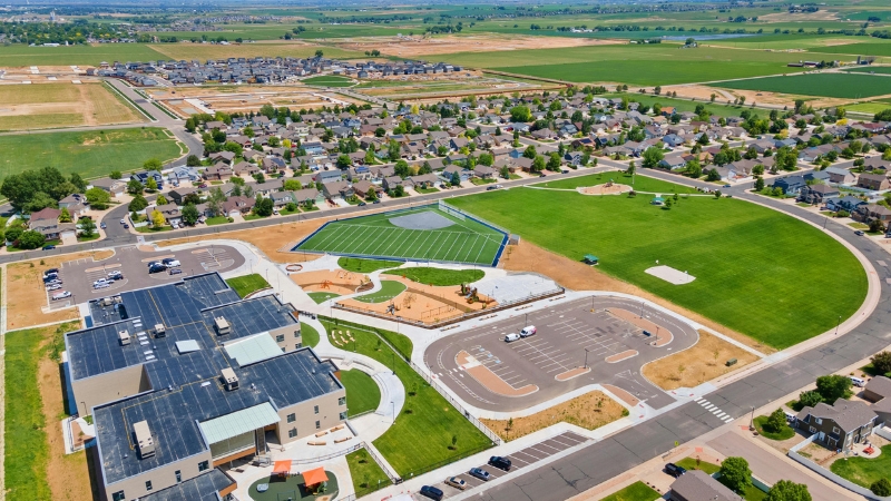 An aerial drone view of a sprawling suburban residential development along the Colorado Front Range corridor.