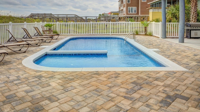 A modern residential backyard swimming pool showing the safety barrier and deck layout for a permit application.